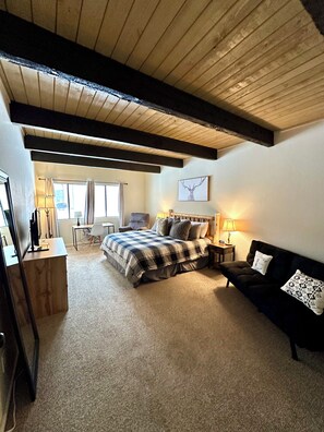 Spacious master bedroom with desk, recliner, futon and Smart TV.