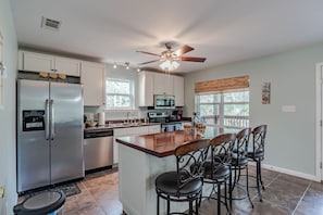 Kitchen fully stocked with dishes and cooking necessities