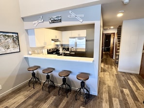 Kitchen with stainless appliances and bar seating for four