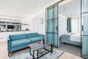 A corner of the living room featuring a turquoise armchair and modern artwork, creating a cozy and inviting space.