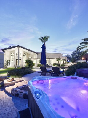 Resort style backyard with private pool, hot tub, lounge chairs, outdoor dining, corn hole, built in grill and fire pit!