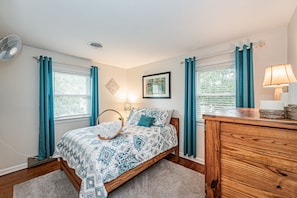 Secondary bedroom with ample closet space, mounted fan, mounted flat-screen TV and queen-sized bed.