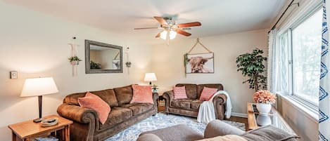 Spacious living room with lots of comfortable seating and natural sunlight.