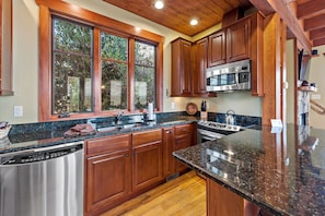 Sleek kitchen with stainless appliances, dishwasher, and drip-style coffeemaker.