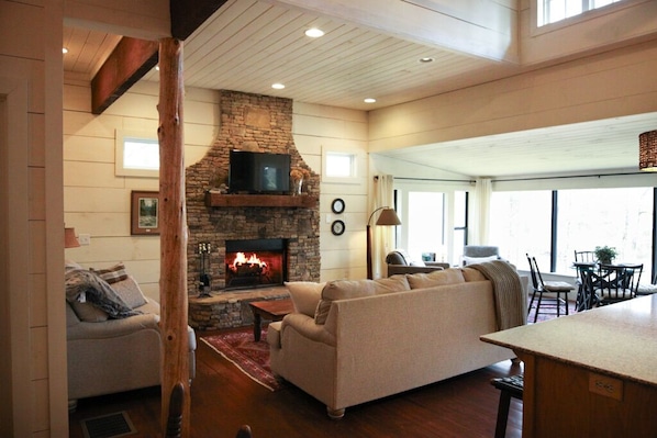 Main room with lots of natural light, working fireplace, & smart TV.