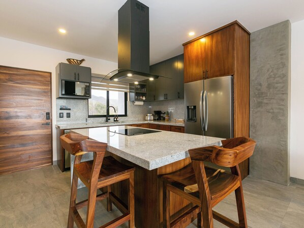 Modern kitchen with counter seating for two—stylish, functional, and perfect for casual meals or morning coffee.
