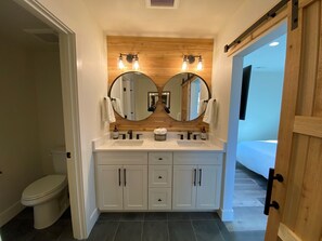En-suite bathroom with double sinks, blow dryer, and extra towels