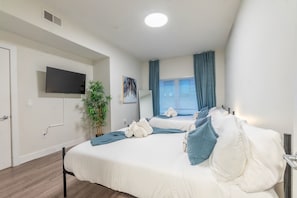 Guest can enjoy watching TV while laying on 1 of 2 Queen-size beds.