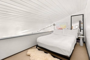 A cozy queen bed is found in the sleeping loft in this condo.