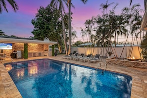 The outdoor features a heated pool, fire pit spot, kitchen, dining for six and lounge areas.