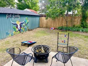 Fenced in backyard w lawn games, firewood(guest must provide) & art mural