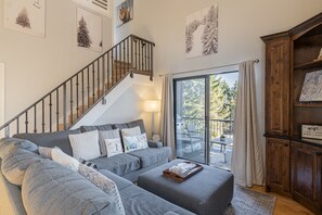 Living room with gas fireplace, Smart tv & sound-bar, plush furnishings, and private deck access