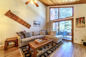 Living room has large picture windows a private deck, and plenty of natural light.