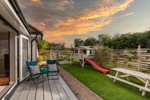 The private garden has outdoor furniture and a playhouse