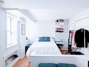 Full-size bed with linens, comforter, several pillows.