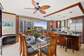 Dining area with eight-seat table and gourmet kitchen, and a large center island with four bar seats.