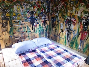 The Okina interior.  Futon sleeps 2 surrounded by an abstract/surreal mural.