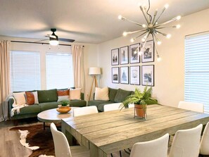 Gather around the dining table or relax on the stylish sectional in this bright, open-concept space—ideal for game nights, meals, or a cozy movie night in.