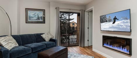 Cozy space with a full sofa, TV, and outdoor patio.