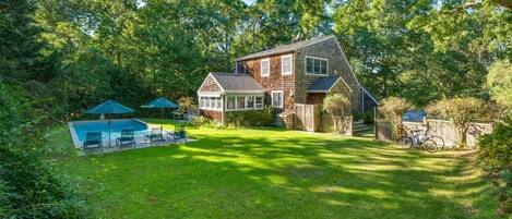 Expansive backyard with outdoor shower; remote awnings around sunroom    