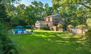 Expansive backyard with outdoor shower; remote awnings around sunroom    