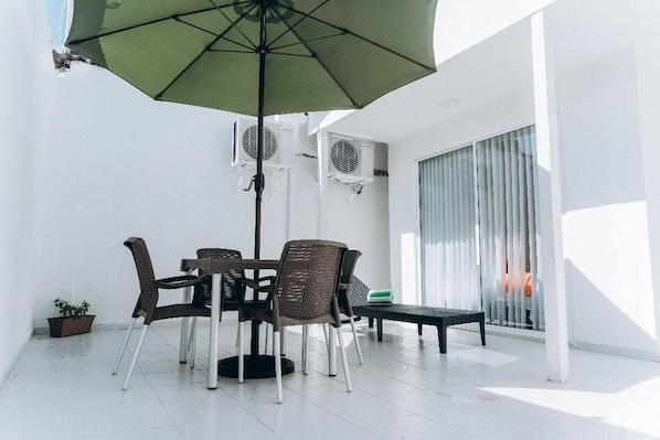 private patio with table and parasol and beach chair for private sunbathing.