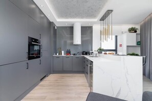 Kitchenette with grey high-backed furniture with oven.