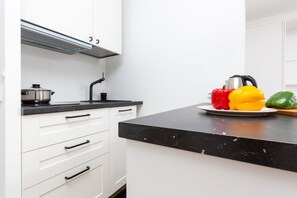 Fully equipped kitchenette with kitchen island, electric kettle, fridge freezer, induction hob and coffee maker.