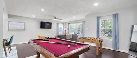 Full-size pool table and foosball table included.