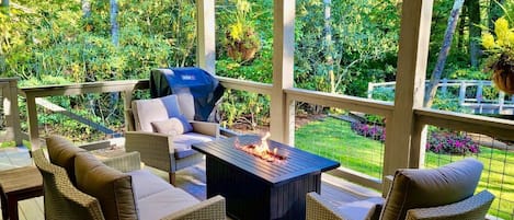 Covered deck with fire table overlooking the back yard