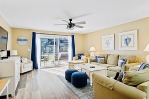 Bright airy living room with patio.  Just steps to the pool and the beach.