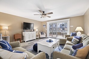 Bright airy living room with patio and just steps to the pool and the beach