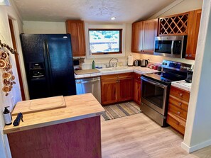 Kitchen with large refrigerator & freezer, dishwasher and views to rear yard.