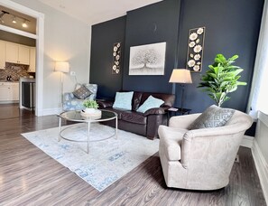 Bright airy living room with love seat and extra oversized chairs.