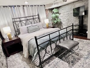 Comfy queen bed with nightstands and ambient lighting.