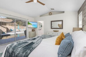 Primary bedroom with king size bed, private bathroom, walk-in closet, smart TV and access to the pool deck.