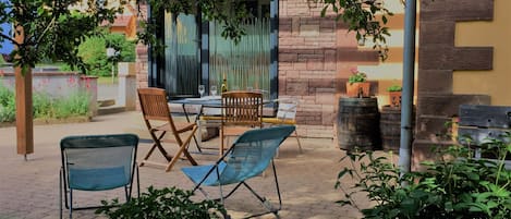 Gîte et sa terrasse orientée au sud. Salon de jardin, chaises longues et BBQ 