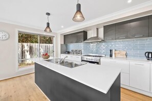A fully equipped kitchen with quality appliances, including a large island bench