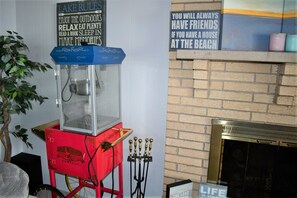 Main living room area with wood-burning fireplace & popcorn machine.