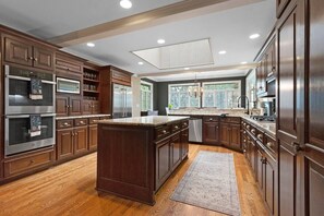 Stunningly beautiful kitchen features top-end appliances.  This room extends to the first open living room and features a dining table that seats eight. 