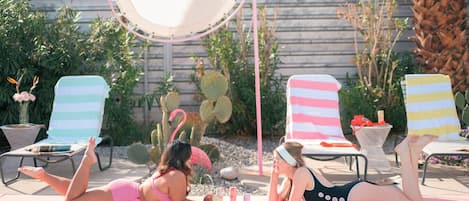 Poolside chill 🌵☀️ Retro stripes, palm trees & sunbathing fun—your perfect desert escape! #PoolVibes #GirlsTrip 🦩👙