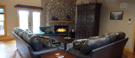 The Great Room has beautiful views, a wood burning stone fireplace and TV