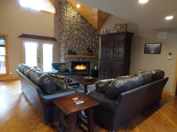 The Great Room has beautiful views, a wood burning stone fireplace and TV