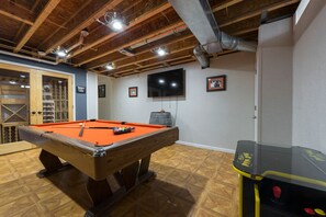 Browns themed basement with pool table, Pac-Man, darts, tv, and more!