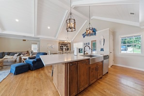 Kitchen island has a farm sink, garbage disposal, dishwasher and 5 bar stools