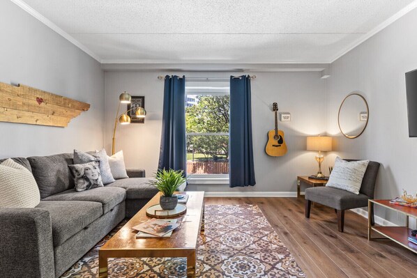 Bright and spacious living room off the kitchen. Smart TV, room darkening shades, and pull-out sleeper sofa for ultimate comfort + Dining table that can seat 4 people!