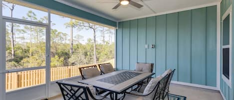 Screened-in back patio with a fan and seating for the whole family! Perfect for family dinners or game nights!