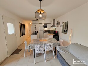 Kitchen opening onto living room with television