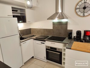 Ausgestattete Küche mit Geschirrspüler, Backofen, Weinkeller, Kühlschrank. 