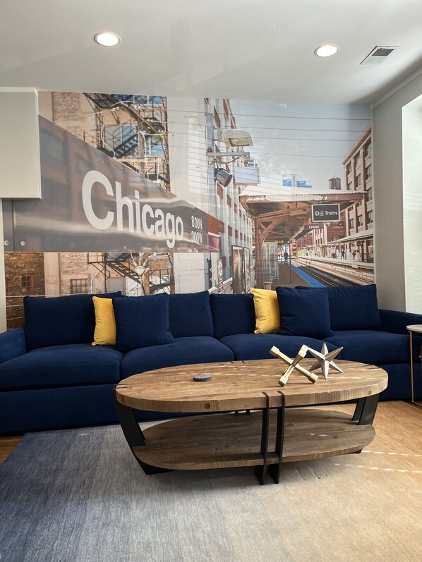 Main living space with massive couch and fun Chicago El mural